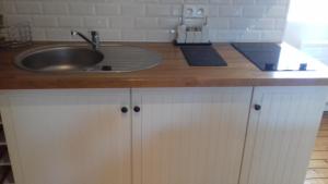 een keuken met een wastafel en een houten aanrecht bij studio Marie in Cancale