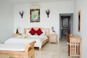 1 dormitorio con 2 camas y mesa en Alam Bali Beach Resort en Amed