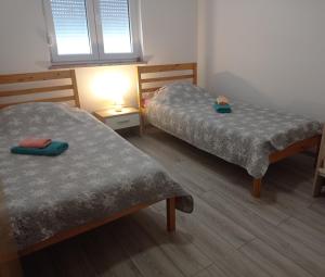 Zimmer mit 2 Betten und einer Lampe in der Unterkunft Apartment Alina in Umag