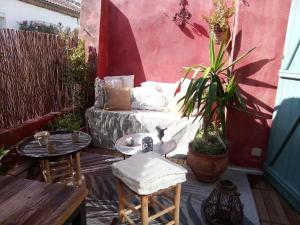 a patio with a couch and a table and chairs at La maison perchee in Aigues-Mortes