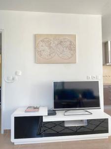 a white table with a television and a picture on the wall at Relais1 Magnifique F3 Disney/Paris in Magny-le-Hongre