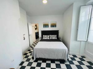 a bedroom with a bed and a checkered floor at Casa Las 4 Esquinas by Casas con Encanto in Medina Sidonia