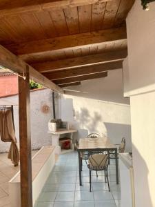 un patio con mesa y sillas bajo un techo de madera en B&B Villa Rosa Angrisano, en Maratea