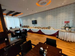 um restaurante com mesas e um bar numa sala em Raoum Inn Sakaka em Sakakah