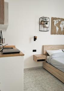 a bedroom with a bed and a desk with a laptop at Petracca Guest House in Monopoli