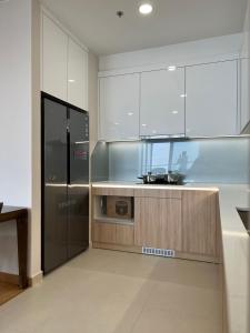  La cuisine est équipée de placards blancs et d'un réfrigérateur. dans l'établissement Căn hộ chung cư The Zei Mỹ Đình, à Hanoï