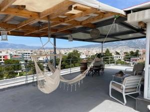 a patio with two hammocks on a roof at Square's View Agia Paraskevi in Athens