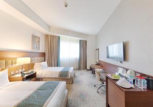 Habitación de hotel con 2 camas y TV de pantalla plana. en Makkah Al Aziziah en Makkah