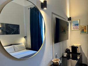 um espelho num quarto com uma cama e uma cama em Arno Boutique em Florença