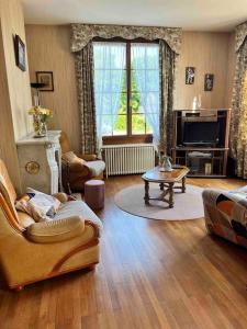 sala de estar con sofá y mesa en Maison de la petite fourmy, en Saint-Sulpice-les-Feuilles