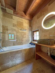 een badkamer met een bad, een wastafel en een spiegel bij Chalet Karibu - 4 Vallees - A 20 mns de Verbier in Bruson