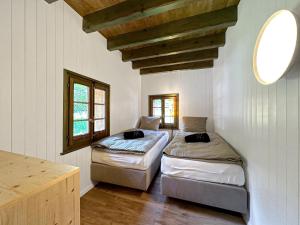 two beds in a room with two windows at Chalet Karibu - 4 Vallees - A 20 mns de Verbier in Bruson