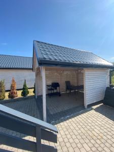 a pavilion with a table and chairs on a patio at Domki i apartamenty "Nadmorska 27A" in Jezierzany