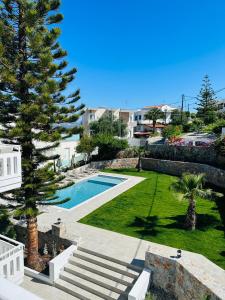 um quintal com uma piscina e uma palmeira em Cost Mari Almyrida New by ZAGO Boutiqe hotels em Almirída