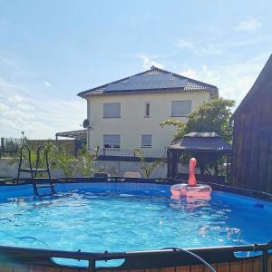 een groot zwembad met speelgoed in het water bij Wellness zur Alleinnutzung mit Ferienwohnung und Fitnessbereich - fitSPA in Sulz am Neckar