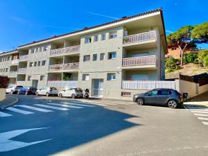 a large apartment building with cars parked in front of it at Coast apartment near Barcelona in Sant Andreu de Llavaneres