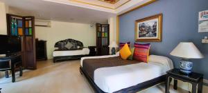 een slaapkamer met een groot bed en een televisie bij Rabbit Resort Pattaya in Pattaya South