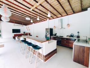 uma cozinha com um balcão e um bar com bancos em Superb pool villa 5 bedrooms em Ban Tai