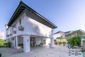 a white house with a courtyard in front of a building at 20BR SwimmingPool Villa Golf View Snooker BBQ in Bayan Lepas