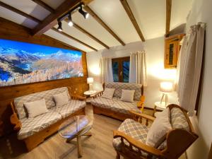 un soggiorno con divani e una grande finestra di CHALET A CERESOLE REALE nel Parco Gran Paradiso a Ceresole Reale