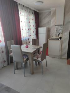 a kitchen with a table and chairs and a refrigerator at Apartament Piero in Pomorie +18 photos