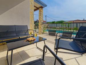 un patio con mesa, sillas y piscina en Villa Morgan, en Umag