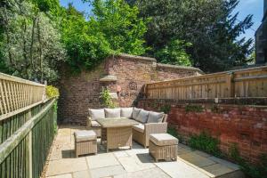 a patio with a table and chairs and a brick wall at The Long Walk: 3Bed & Garden in Windsor