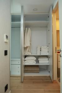 Pullman Prime Istanbul-2-BDROOM في إسطنبول: خزانة ملابس مع مناشف بيضاء على الأرفف