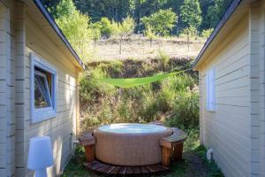 een hot tub in de hoek van een tuin bij Les Cabanes d'Hestia in La Salvetat