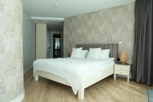 1 dormitorio con 1 cama blanca grande con almohadas blancas en Prime Residence Istanbul-2-BDROOM en Estambul