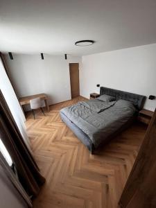a bedroom with a bed and a wooden floor at Apartment in the old town in Kėdainiai