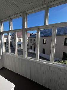 a screened porch with four windows and a building at Apartment in the old town in Kėdainiai