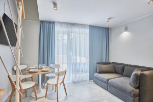 a living room with a couch and a table and chairs at Timber Apartments by Baltic Home in Świnoujście