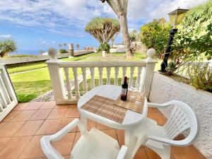 a white table and chairs on a patio with a bottle of wine at RedVelvet in Tacoronte