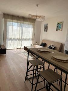 - un salon avec une table, des chaises et un canapé dans l'établissement Appartement port de Vannes, à Vannes