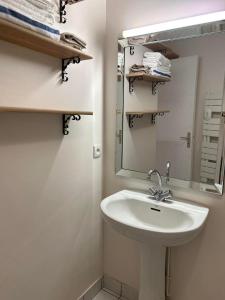 La salle de bains est pourvue d'un lavabo et d'un miroir. dans l'établissement Appartement port de Vannes, à Vannes