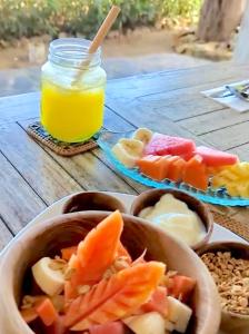 une table avec des bols de fruits et un pot de jus dans l'établissement The Club Villas Lombok, à Sekotong