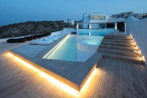 una piscina en la azotea de una casa con luces en White Stone Mykonos en Agios Ioannis Mykonos