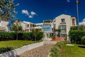 a villa with a garden in front of a building at The Pelican Beach Resort & SPA - Adults Only in Olbia
