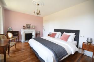 a bedroom with a large bed and a fireplace at Manoir de Kerguestenen in Gestel