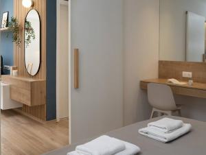a bathroom with a sink and a table with towels at Laguna Blue Home in Agios Nikolaos
