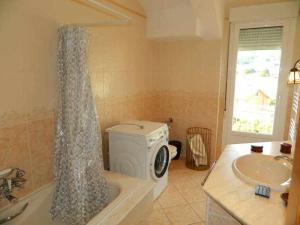 a bathroom with a washing machine in a tub at Piso en primera línea de playa en Lariño in Lariño