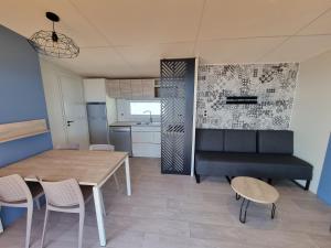聖拉斐爾的住宿－Mobil Home Neuf Vue mer，用餐室以及带桌椅的厨房。