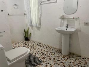 łazienka z toaletą i umywalką w obiekcie White Beach Front and Cottages w mieście Buruanga
