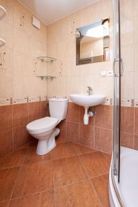 a bathroom with a toilet and a sink and a shower at Domki, pokoje u Małgosi in Sztutowo +17 photos