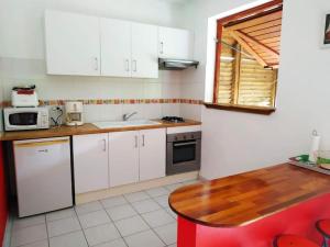 a kitchen with white cabinets and a wooden table at Studio avec une vue dominante in Sainte-Anne