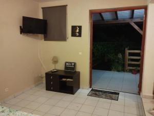 a living room with a door open to a patio at Studio avec une vue dominante in Sainte-Anne