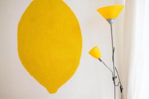 a yellow surfboard on a wall next to a lamp at Amber Private Rooms in Riga