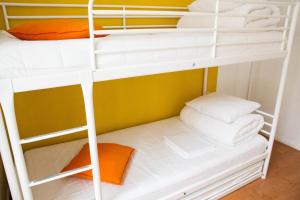 a bunk bed with white bunk beds in a room at Amber Private Rooms in Rīga