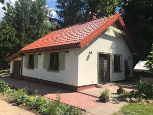 a small white house with an orange roof at Mazurski Domek Brożówka 50 m od plaży in Brożówka